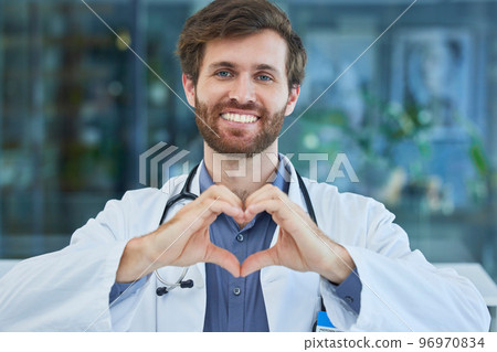 Man, doctor and heart sign with smile, support and healthcare in hospital. Medical professional, male and hand gesture for shape, love or solidarity for health, wellness or happy for help or portrait 96970834