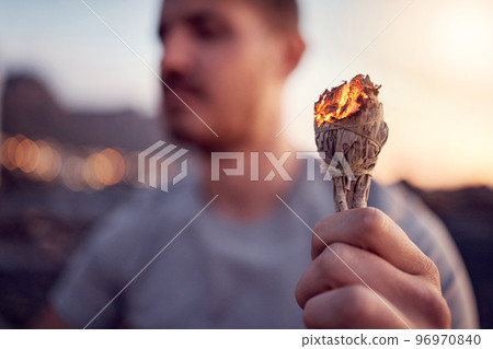 Man, burning sage and zen meditation outdoor for spiritual health, chakra wellness or to cleanse negative energy. Mindfulness, aromatherapy and male relaxing, meditating outside and performing ritual 96970840