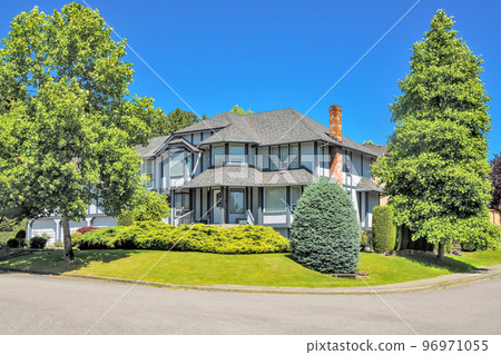 Big residential house on the street with brick chimney and steps on front yard 96971055