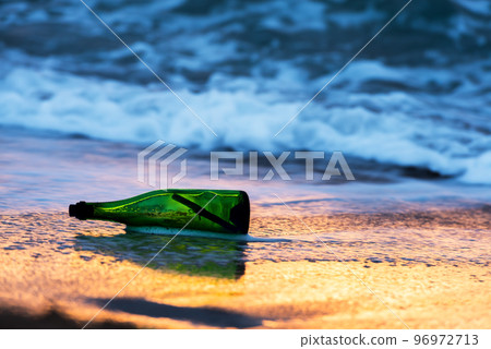 Green glass bottle with paper message Green glass bottle with paper message 96972713