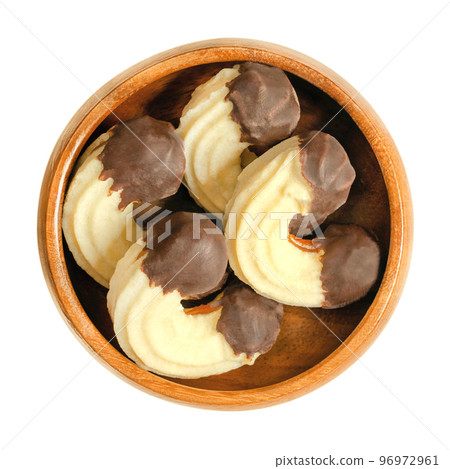 Crescent shaped butter cookies, Linzer Kipferl, in a wooden bowl. Traditional Austrian Christmas biscuits. Two layers of shortbread glued together with apricot jam, both sides dipped into chocolate. 96972961