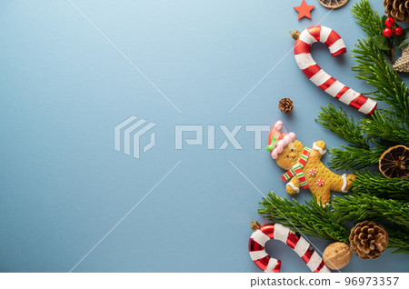 Christmas mock up with fir tree branches, ginger bread cookies, Christmas candy cane on blue background. Flat lay. Top view Christmas mock up with fir tree branches, ginger bread cookies, Christmas candy cane on blue background. Flat lay. Top view 96973357