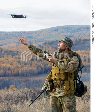 Vertical photo of an artillery spotter or military observer launch a drone into the sky for reconnaissance in enemy territory. Vertical photo of an artillery spotter or military observer launch a drone into the sky for reconnaissance in enemy territory. 96973980
