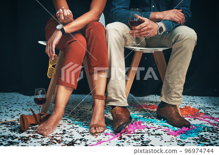 Feet, man and woman sitting at a party to celebrate new years eve and socialise together. Legs, couple and celebrating while partying together at a festive celebration or event with confetti 96974744