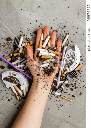 Hand holding pile of cigarettes with dirt. Concept of enviroment pollution. 96974815