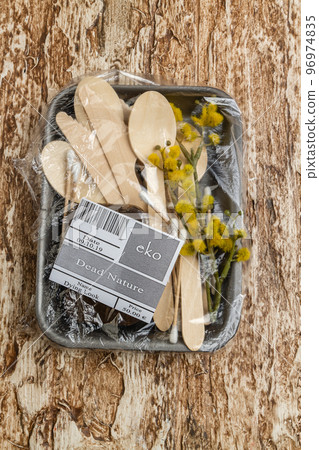 Wooden utensils with spoon and herb wrapped in plastic. Dead nature concept. Vertical shot top view. Wooden utensils with spoon and herb wrapped in plastic. Dead nature concept. Vertical shot top view. 96974835