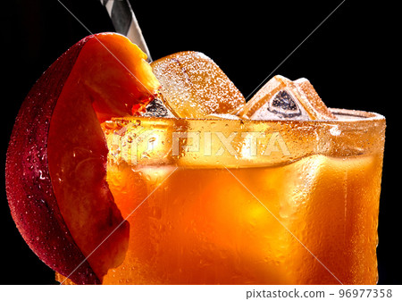Fruit healthy cocktail from mango juice and ice on black background Fruit healthy cocktail from mango juice and ice on black background 96977358