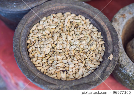 Pods of green cardamom in a large pottery Pods of green cardamom in a large pottery 96977360