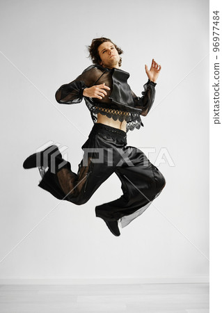 Non binary man wearing lace outfit jumping 96977484