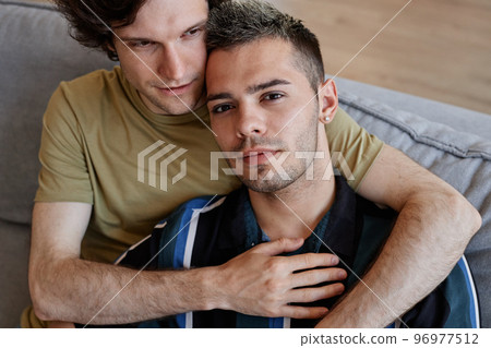 Gay couple embracing at home 96977512