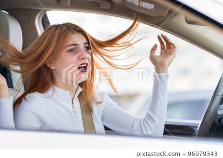 Closeup portrait of pissed off displeased angry aggressive woman driving a car shouting at someone. Negative human expression consept. Closeup portrait of pissed off displeased angry aggressive woman driving a car shouting at someone. Negative human expression consept. 96979343