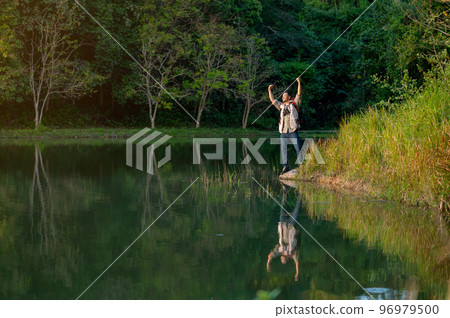 Wide shot Asian man with bag and journey accessories action of hands up and look happy Wide shot Asian man with bag and journey accessories action of hands up and look happy 96979500