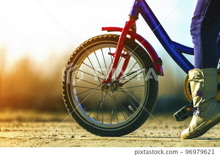 Close-up detail of little girl child feet on a child bicycle 96979621