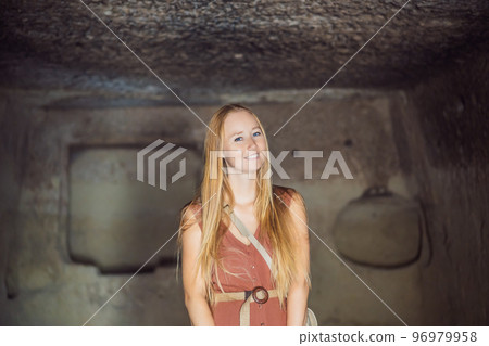 Young woman exploring valley with rock formations and fairy caves near Goreme in Cappadocia Turkey Young woman exploring valley with rock formations and fairy caves near Goreme in Cappadocia Turkey 96979958