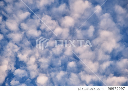 Bright landscape of white puffy clouds spread on blue clear sky Bright landscape of white puffy clouds spread on blue clear sky 96979997