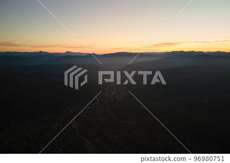 Aerial view of dark mountain hills at sunset. Hazy peaks and misty valleys in evening 96980751