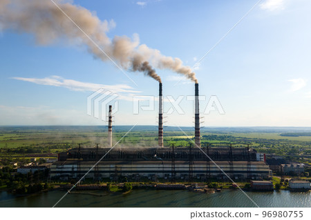 Aerial view of coal power plant high pipes with black smokestack polluting atmosphere. Electricity production with fossil fuel concept. Aerial view of coal power plant high pipes with black smokestack polluting atmosphere. Electricity production with fossil fuel concept. 96980755