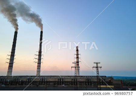 Aerial view of coal power plant high pipes with black smokestack polluting atmosphere. Electricity production with fossil fuel concept Aerial view of coal power plant high pipes with black smokestack polluting atmosphere. Electricity production with fossil fuel concept 96980757