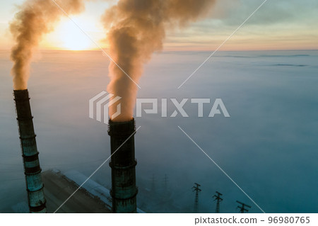 Aerial view of coal power plant high pipes with black smoke moving up polluting atmosphere at sunset. 96980765