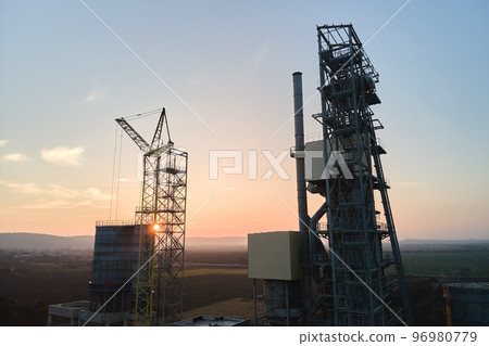 Aerial view of cement factory with high steel plant structure and tower crane at industrial production area. Manufacture and global industry concept Aerial view of cement factory with high steel plant structure and tower crane at industrial production area. Manufacture and global industry concept 96980779