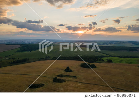 Aerial landscape view of yellow cultivated agricultural field with ripe wheat on bright summer evening Aerial landscape view of yellow cultivated agricultural field with ripe wheat on bright summer evening 96980871