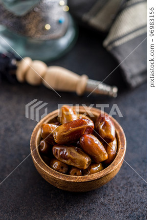 Dried dates fruit in bowl on black table. 96983156