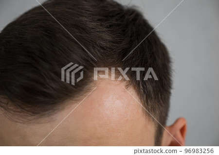 Handsome unshaven man looking into the mirror in bathroom. 96983256