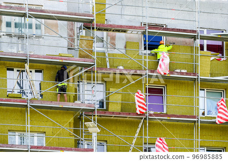 Thermal insulation of the facade of an apartment building with thick mineral rock wool slabs 96985885