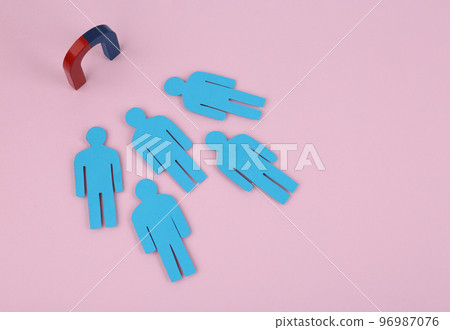 Magnet attracting paper people on pink background, above view 96987076