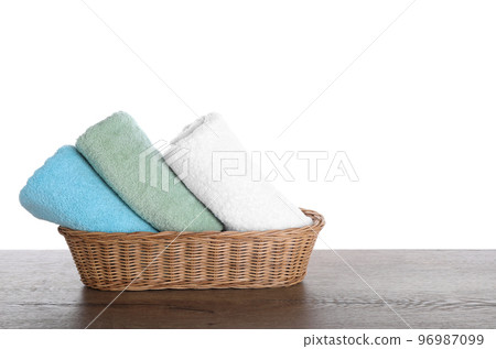 Fresh towels on wooden table against white background 96987099