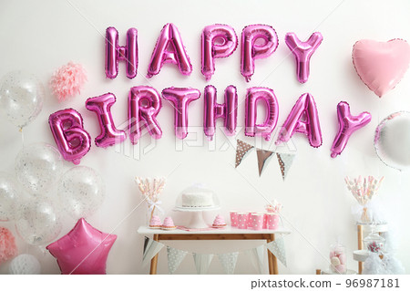 Phrase HAPPY BIRTHDAY made of pink balloon letters on white wall 96987181