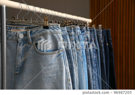 Rack with different stylish jeans, closeup view Rack with different stylish jeans, closeup view 96987205