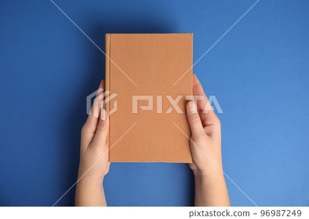 Woman with book on blue background, top view. Space for design 96987249
