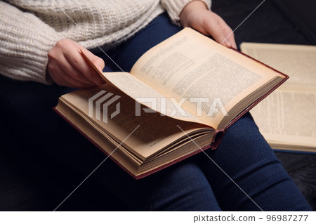 Young woman reading book at home, closeup Young woman reading book at home, closeup 96987277