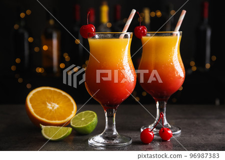 Fresh alcoholic Tequila Sunrise cocktails on grey table Fresh alcoholic Tequila Sunrise cocktails on grey table 96987383
