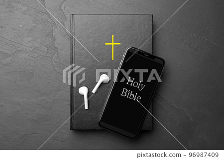 Bible, phone and earphones on black background, top view. Religious audiobook Bible, phone and earphones on black background, top view. Religious audiobook 96987409