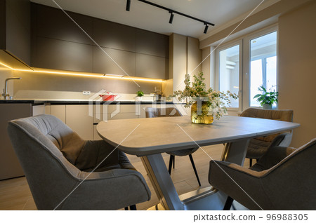 Modern grey luxurious kitchen with dining table in studio apartment Modern grey luxurious kitchen with dining table in studio apartment 96988305