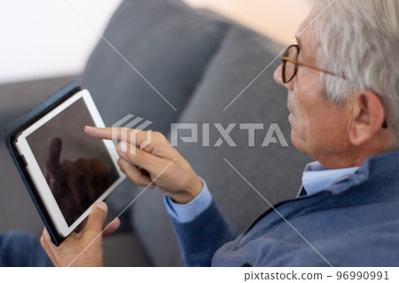 Senior man touching tablet screen Senior man touching tablet screen 96990991