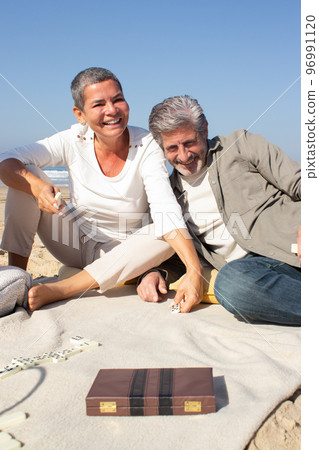 Happy senior couple enjoying dominoes game Happy senior couple enjoying dominoes game 96991120
