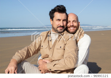 Portrait of smiling gays embracing on beach 96991121