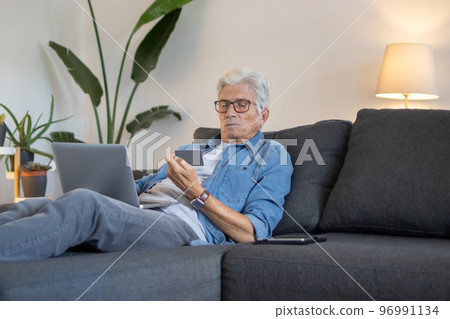 Mature man entering card details for buying products online Mature man entering card details for buying products online 96991134