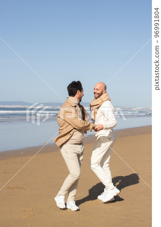 Gay couple spinning around 96991804
