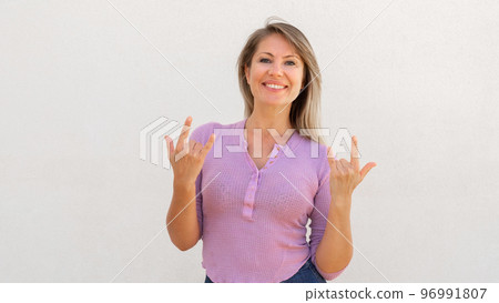 Cheerful Caucasian woman showing rock signs 96991807