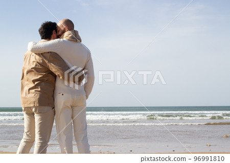 Affectionate gays hugging on beach 96991810