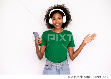 Portrait of happy young woman in headphones holding mobile phone 96991837