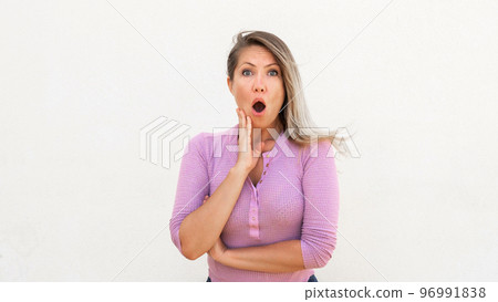 Shocked Caucasian woman touching face 96991838