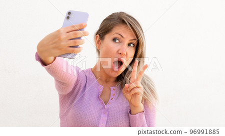 Excited Caucasian woman taking selfie Excited Caucasian woman taking selfie 96991885