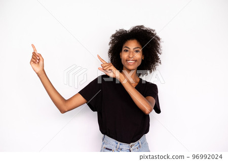 Portrait of happy young woman pointing aside 96992024