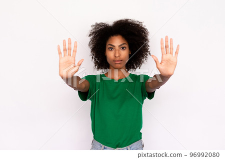 Portrait of serious young woman making stop gesture 96992080