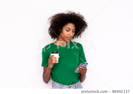 Portrait of serious young woman with coffee reading message Portrait of serious young woman with coffee reading message 96992137